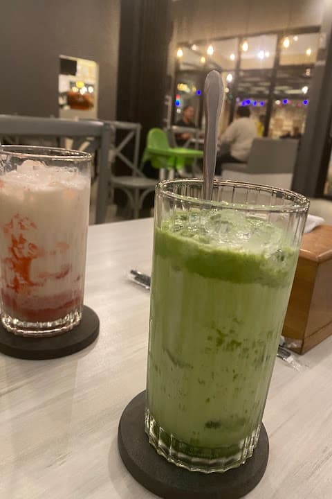 Es matcha latte dan minuman strawberry dingin di atas meja kafe