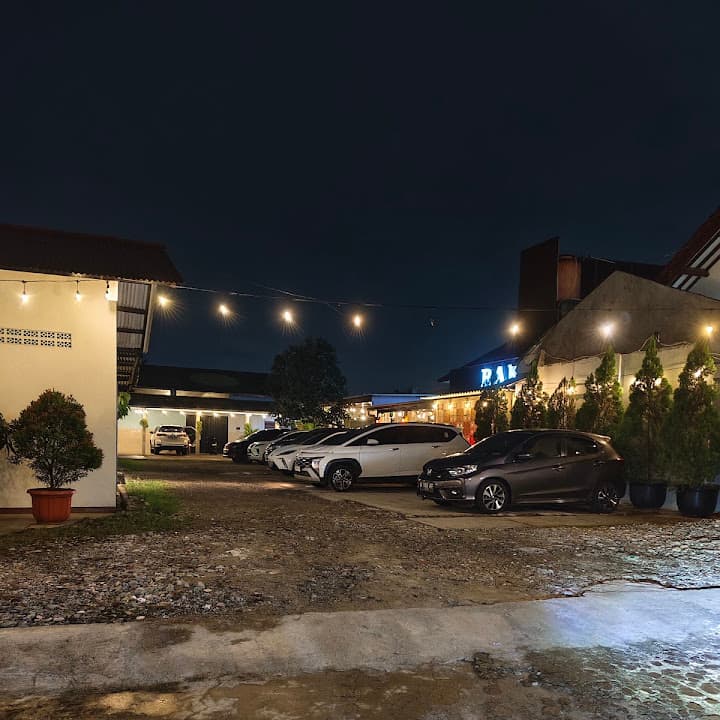Area parkir BAKALKOPI pada malam hari dengan lampu untaian dan mobil terparkir