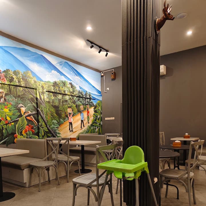Ruang dalam dengan mural kebun kopi, meja keluarga, dan kursi anak